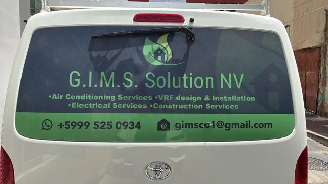The G.I.M.S. Solution NV van with the company logo, services and phone number on the rear window